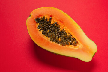 Papaya fruit on a orange background. Half papaya.