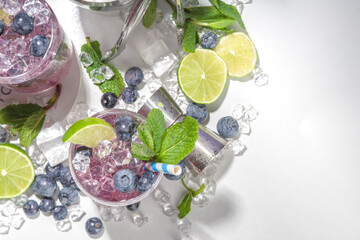 Blueberry citrus summer cooling drink, iced berry mojito lemonade cocktail with blueberries, mint and lime
