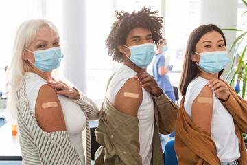 Diverse Group Showing Vaccinated Arm With Adhesive Bandage In Clinic - obrazy, fototapety, plakaty