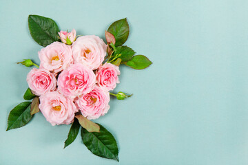 Beautiful summer and spring card with a bouquet of pink roses on a modern green background. Bouquet of pink roses top view copy space for text