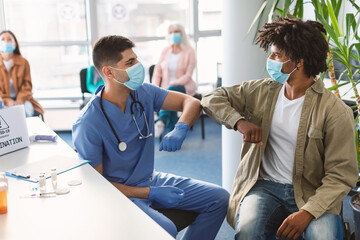 Black Guy In Medical Mask Bumping Elbows Meeting Male Doctor