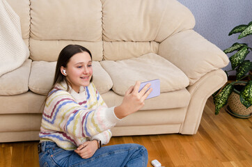 Happy teenage girl using smartphone, video calling, online streaming for social media at home. Generation Z influencers.