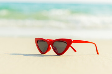 Red sunglasses on the sand beautiful summer beach