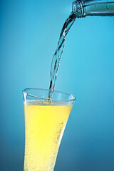 Fruit sparkling water is poured into a glass.