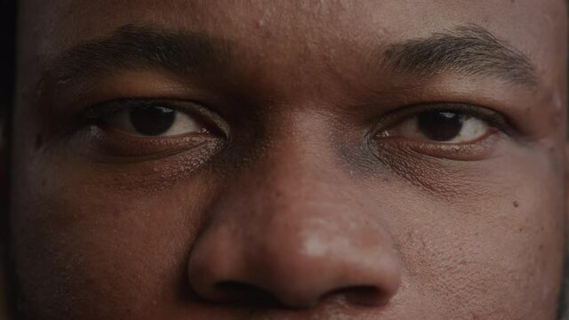 Extreme close-up of a black man's eyes opening in slow motion