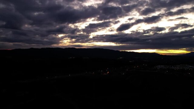 Aerial drone hyperlapse Clouds moving over mountain silhouette at Sunset