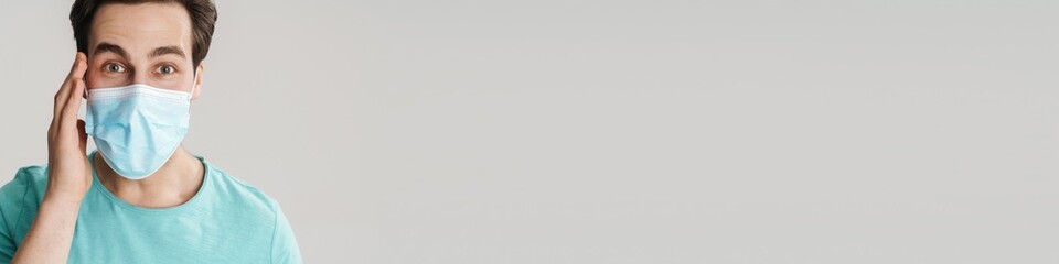 Caucasian handsome guy in protective mask looking at camera