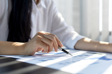 A business finance woman is reviewing a company's financial documents prepared by the Finance Department for a meeting with business partners. Concept of validating the accuracy of financial numbers.