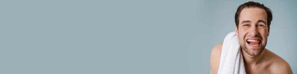 Obraz premium Happy brunette bearded shirtless man with towel