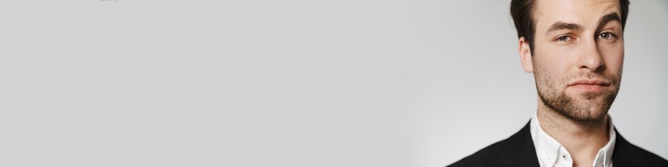 Obraz premium Unshaven brunette man in jacket posing and looking at camera