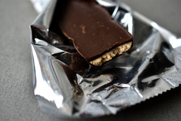 Chocolate candy in a wrapper on a gray background