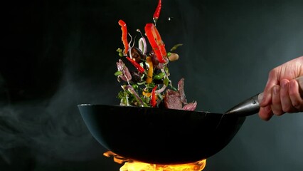 Super slow motion of flying asian beef meat with vegetable from pan. Filmed on high speed cinema camera, 1000 fps.