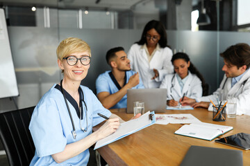 Fototapeta premium Portrait of young blonde woman doctor having brainstorming with colleagues