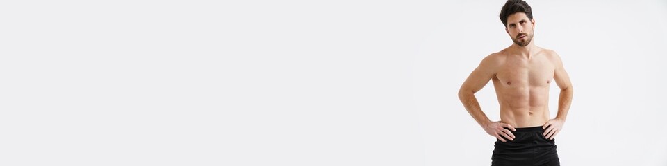 Fototapeta premium Shirtless athletic sportsman posing and looking at camera