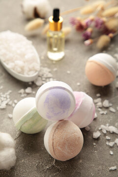 Composition with bath bombs, sea salt, dry flowers on grey background. Vertical photo