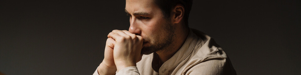 Fototapeta premium Tired bored mid aged brunette man looking at laptop
