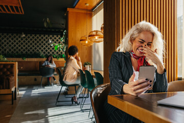 Woman at coffee shop using mobile phone