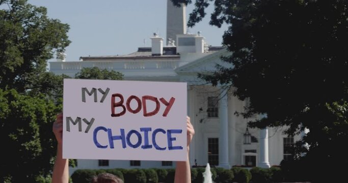 WASHINGTON - Circa September, 2020 - A man holds a MY BODY MY CHOICE protest sign outside of the White House on a sunny day.	