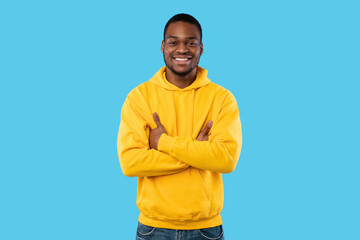 Happy African American Man Posing Crossing Hands On Blue Background