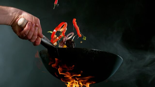 Super slow motion of flying asian beef meat with vegetable from pan. Filmed on high speed cinema camera, 1000 fps. Speed ramp effect.
