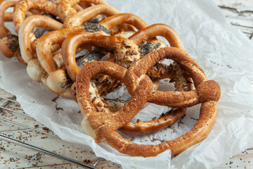 Fresh prepared homemade soft pretzels. Different types of baked pretzels with seeds on a black background