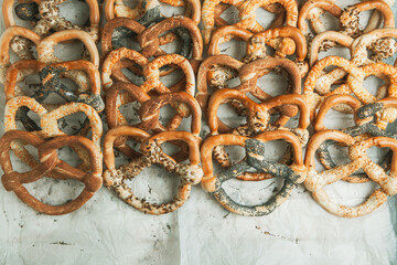 Fresh prepared homemade soft pretzels. Different types of baked pretzels with seeds on a black background
