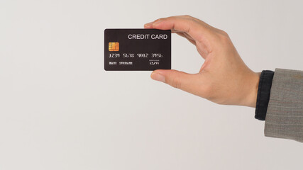 A hand is holding black credit cards and wearing suit on white background.