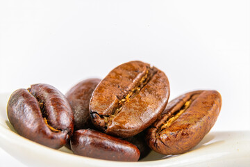 Five coffee beans on a small spoon