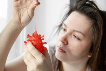 Illness young woman with holding red virus. Sick woman with symbol of coronavirus