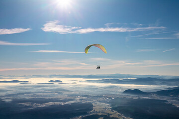 Paragliding with parachute at clear sunny sky in winter.