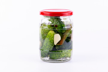 Pickled cucumbers in glass jar on white background.