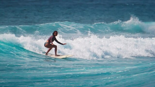 Woman surfs the wave in the ocean