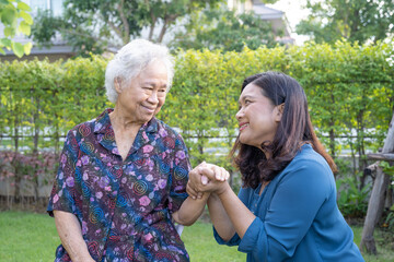 Asian elderly woman with caregiver enjoy and happy in nature park.