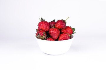 Fresh strawberry in white ceramic plate on white background.