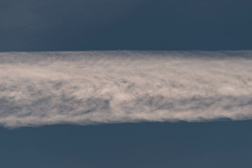 Fototapeta na wymiar Chmury kondensacyjne po przelocie samolotu na błękitnym niebie.