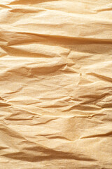 Texture of crumpled paper corrugated beige gold color closeup