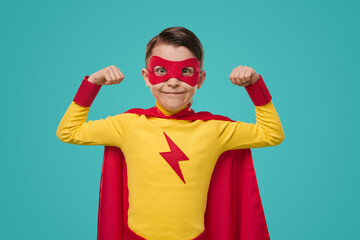 Strong boy in superhero costume showing biceps