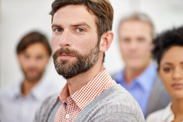 Confident in his team-leading abilities. Portrait of a group of young office professionals.