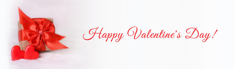 Valentine's Day background. Gift box with a red bow and two hearts on a white background. Valentines day concept.Happy Valentine's Day.Copy space. Banner