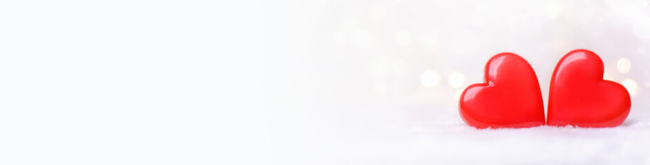 Fototapeta premium Two red hearts on a white background with bokeh. Postcard for Valentine's Day.Banner.Happy Valentine's Day.Copy space