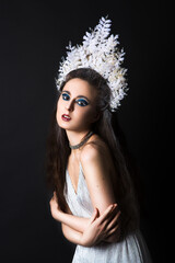 Beautiful woman with creative makeup as Snow Queen or Ice Fairy isolated on black background.	