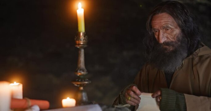 Aged hermit preparing to send letter