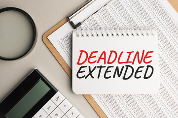 Notepad with text DEADLINE EXTENDED, with black marker on white background