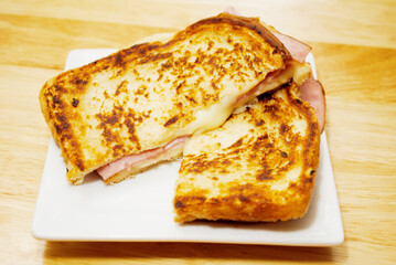 Grilled Cheese and Ham Sandwich Served on a White Plate