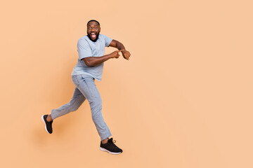 Full length body size view of attractive cheerful guy jumping showing time running isolated over...