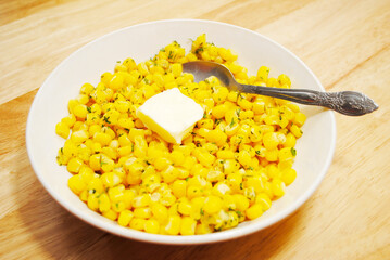 Fresh Yellow Corn Served in a White Bowl with a Pat of Butter