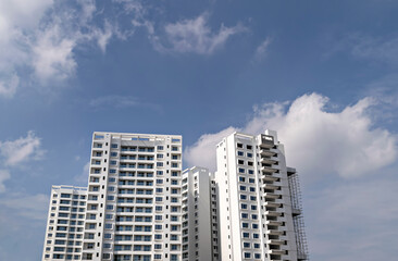 Image of tall buildings under construction with blue sky background in Pune, Maharashtra.