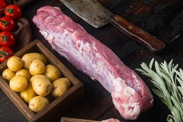 Whole boneless pork fillet loin with ingredients and herbs for grill  with old butcher cleaver...