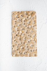 Whole grain crisp bread, on white stone table background, top view flat lay