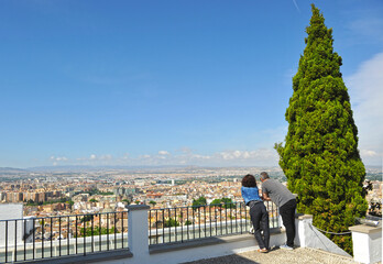 Pareja en el mirador de un carmen de Granada disfrutando una vista panorámica de la ciudad,...